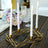 Gold candle holder with four white candles on a wooden table.