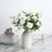 White rose bouquet in a minimalist vase on a marble surface.