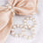 Elegant pearl napkin rings with silver accents on a silk napkin.