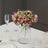 Pink rose bouquet in a clear vase on a dining table setting.