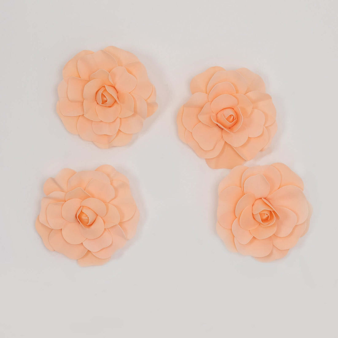 Peach floral embellishments in various sizes on a white background
