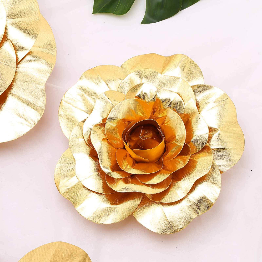 Gold floral decor piece with layered petals and a central bloom.