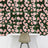 Floral wallpaper with pink roses on a green background in a modern workspace setting.