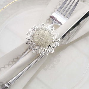 Silver decorative napkin holder with fork and knife on a plate.