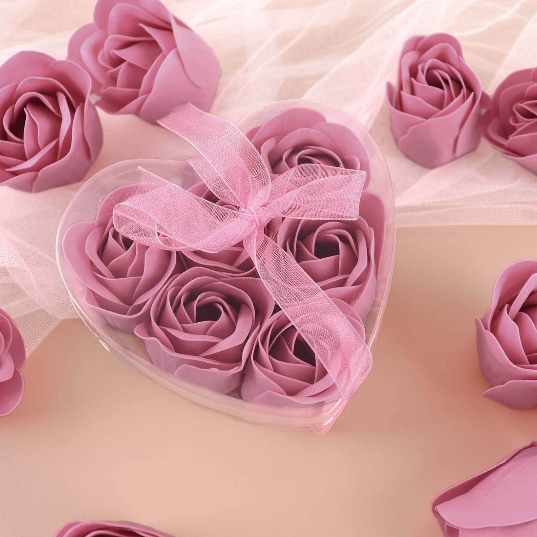 Pink rose soap flowers in a heart-shaped box with a ribbon.