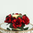 Red roses arrangement with a candle on a decorative table.