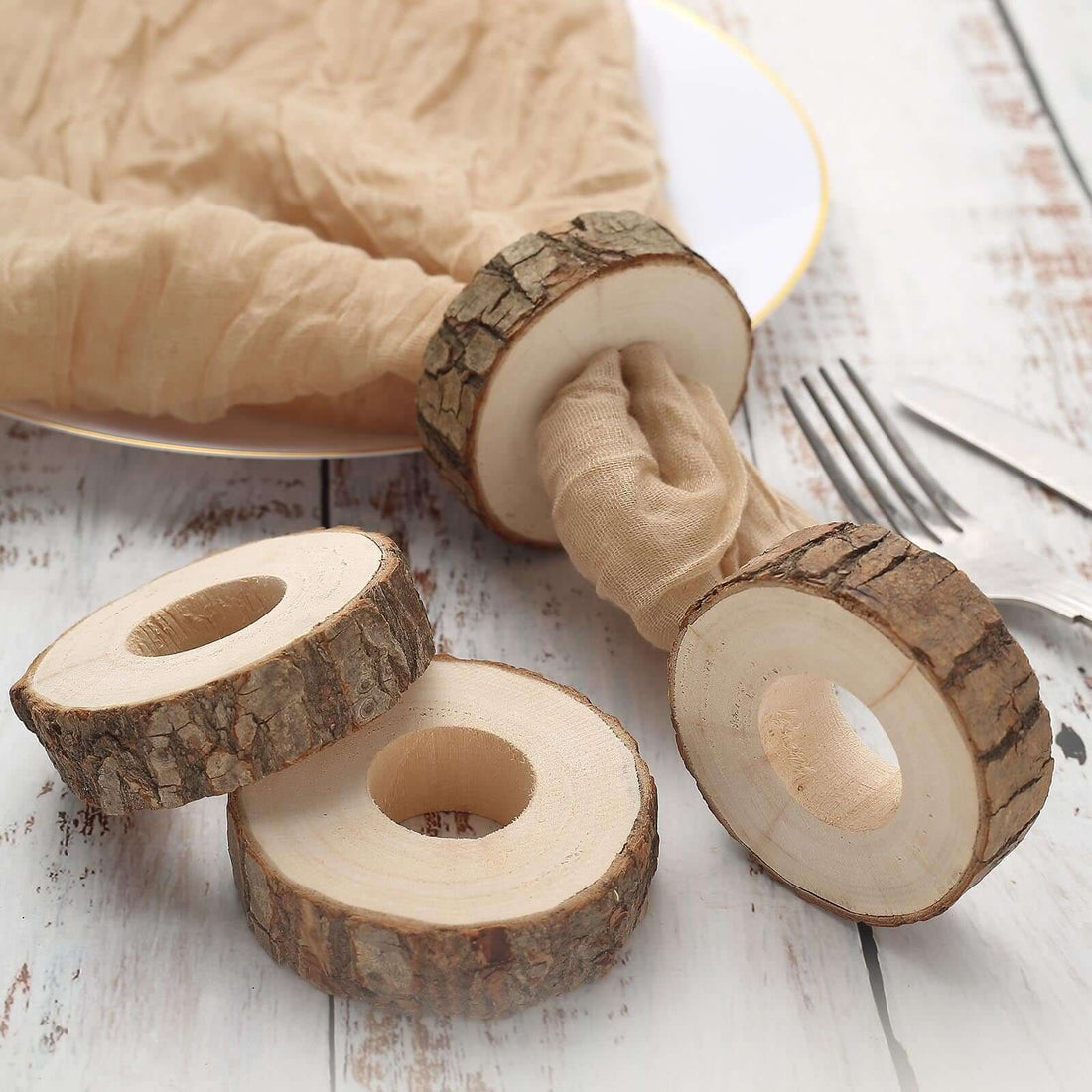 Wooden napkin rings with natural bark finish on a rustic table setting.