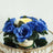 Blue rose bouquet with green leaves and a candle centerpiece.