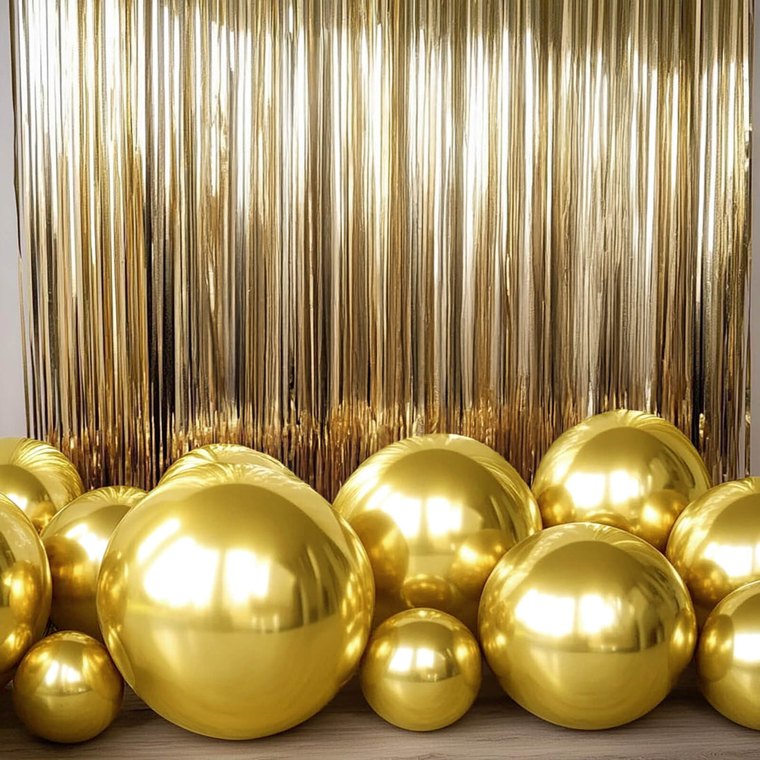 Gold balloons in various sizes against a shiny gold backdrop.