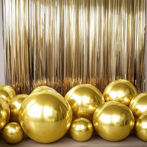 Gold balloons in various sizes against a shiny gold backdrop.