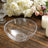 Clear plastic bowl with floral etching on a rustic wooden table.