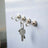 Metal key hooks with keys hanging on a white wall.