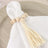 Beaded napkin ring with tassel on a white napkin.