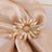 Gold flower ring with crystal accents on a satin fabric.