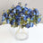 Blue floral arrangement in a clear glass vase.