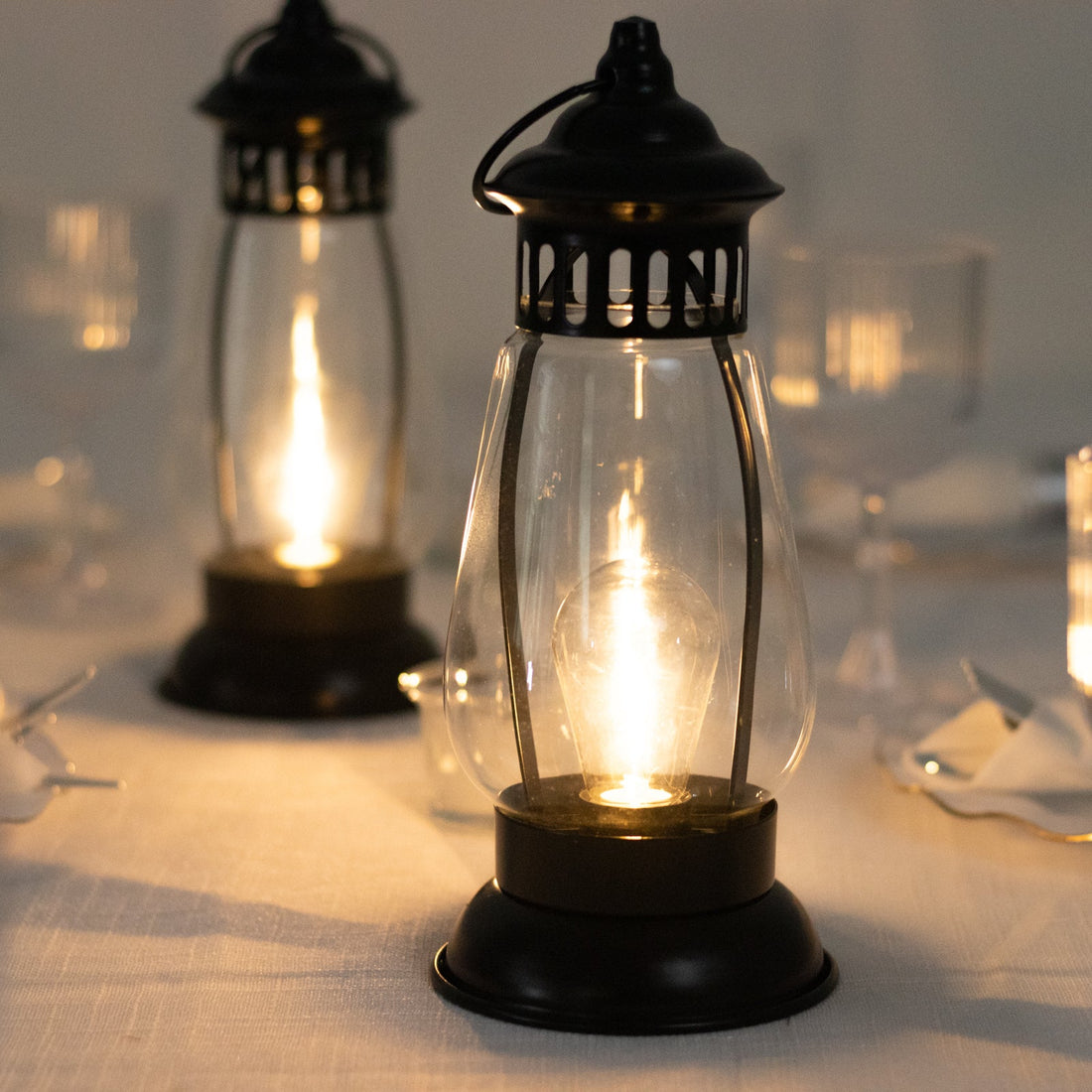 Vintage lanterns casting warm light on a dining table.