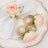 Rose-themed napkin rings and holder on a decorative plate.