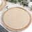 Round woven placemat with fringe detail, perfect for table settings.