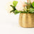 Gold textured vase with artificial flowers arrangement.