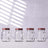 Set of four glass jars with handles and red lids.