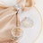 Elegant silver rings with clear gemstones displayed on a silk napkin.