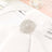 Elegant silver napkin holder with intricate design on a white napkin.