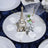 Eiffel Tower centerpiece on a reflective table setting with rose petals.