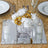 Elegant floral centerpiece with white and gold flowers, candles, and mirrored base.