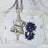 Eiffel Tower replica on a mirrored surface with decorative flower and pearls.