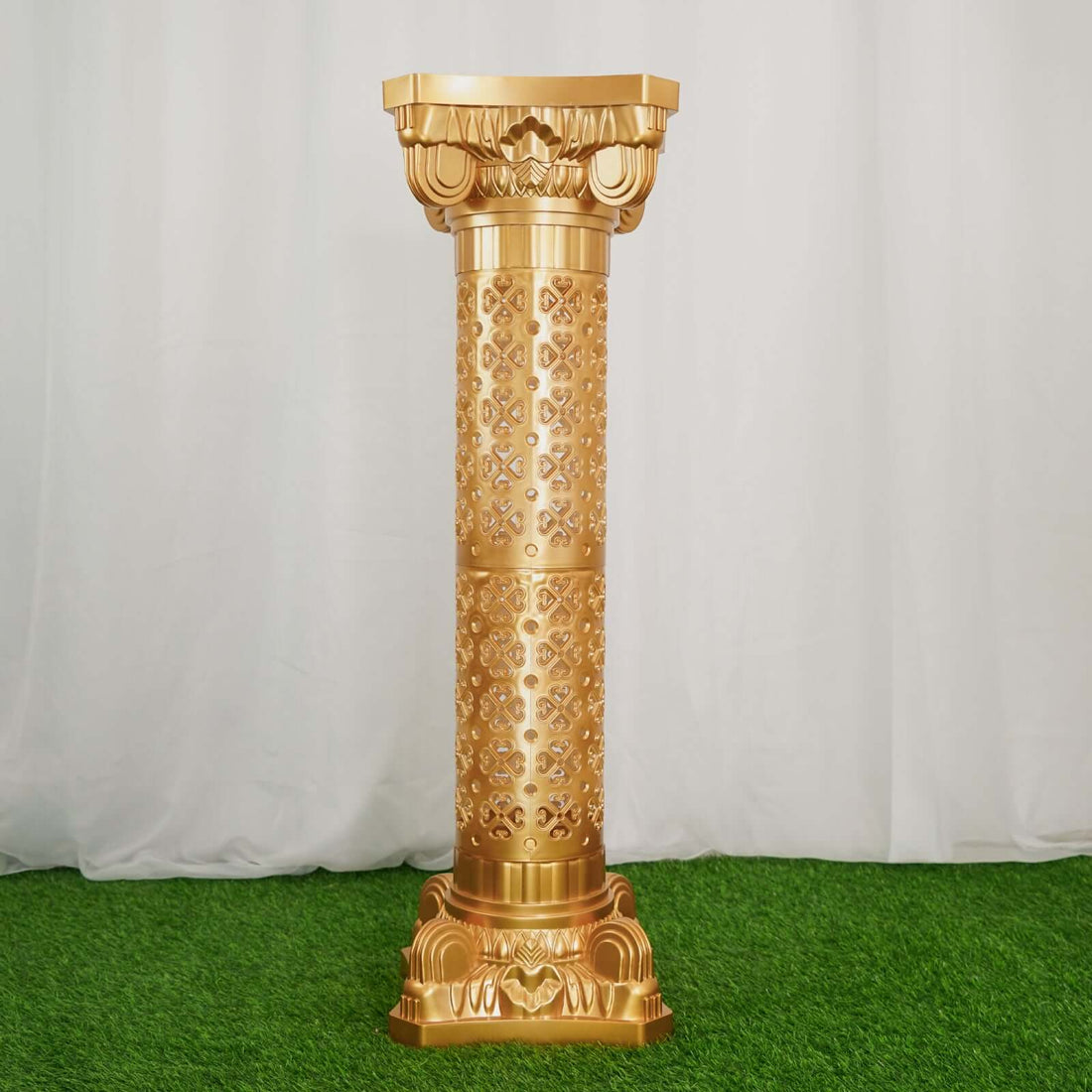 Golden decorative column with intricate patterns against a white backdrop.