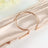 Rose gold napkin ring on satin fabric.