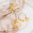 Gold butterfly napkin ring and bracelet on soft fabric and plate.