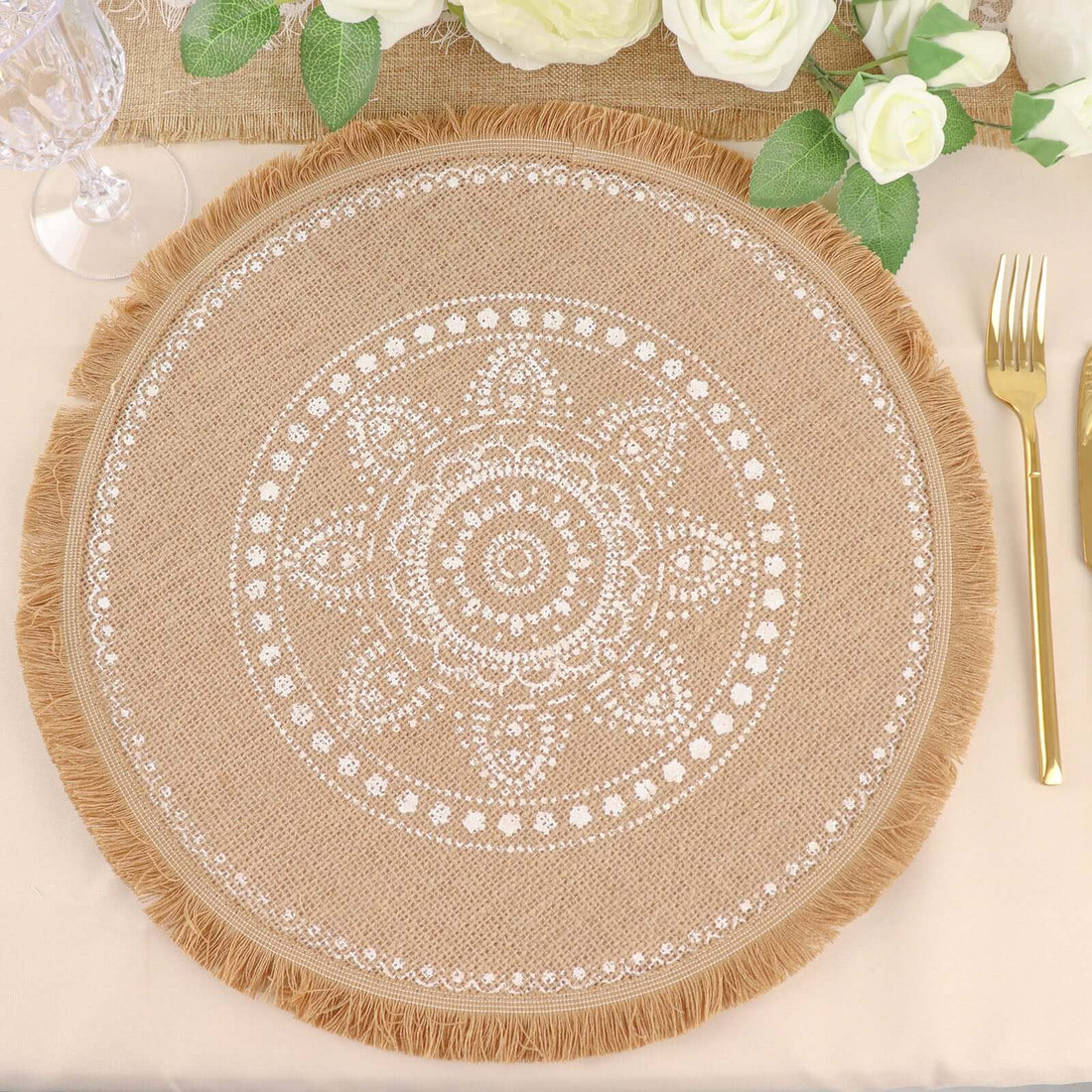 Decorative round jute placemat with intricate white pattern and fringed edges.