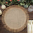 Braided round placemat with fringed edges on a wooden table