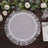 White fringed placemat surrounded by greenery and candles.