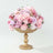 Pink floral arrangement in a gold pedestal vase