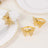 Gold butterfly napkin rings on a white table setting.