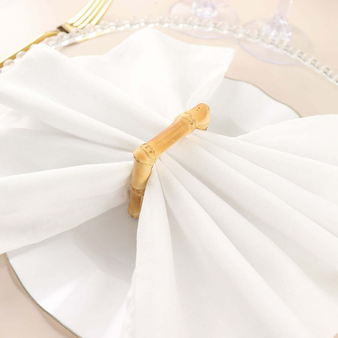 Bamboo napkin ring on white folded napkin, decorative table setting