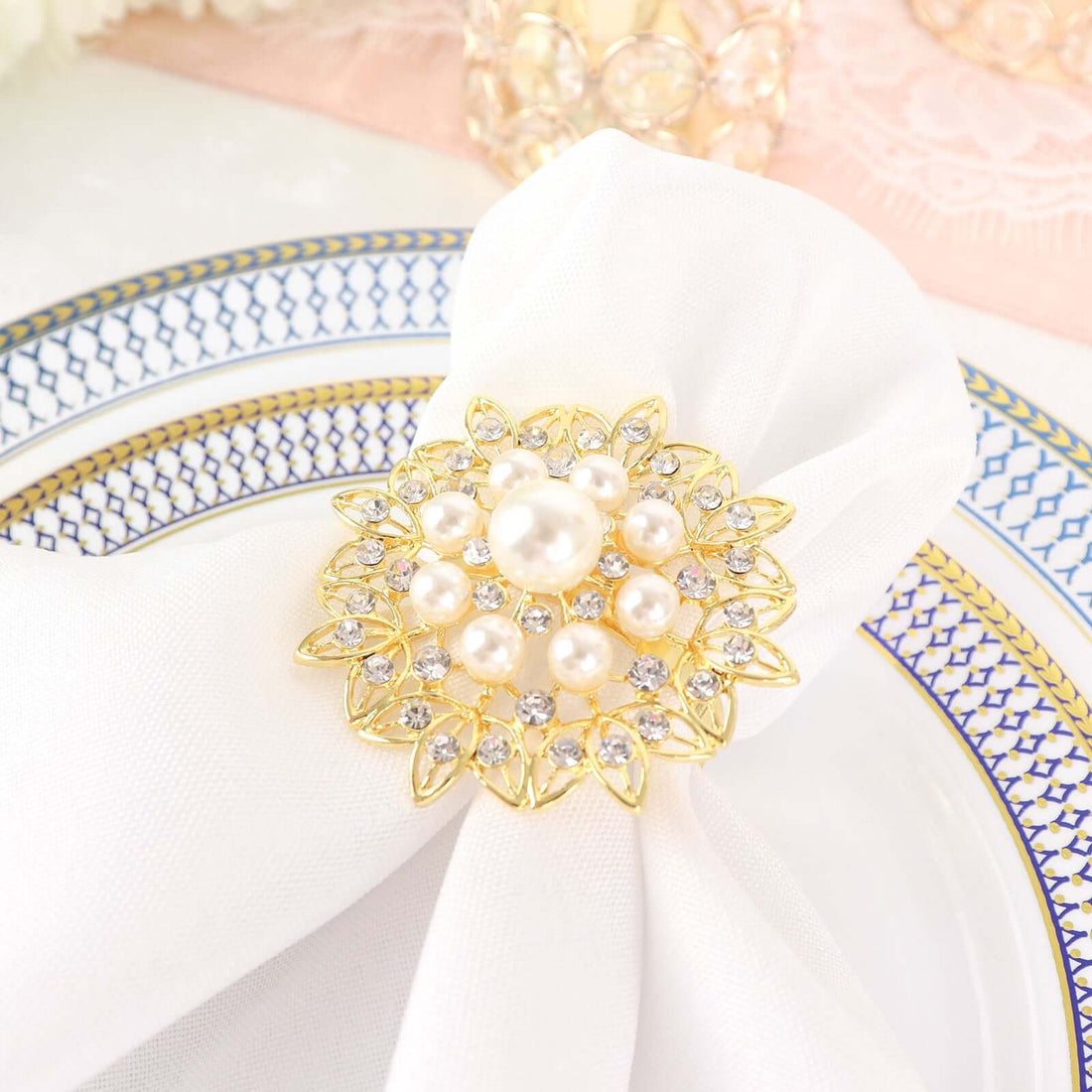 Elegant gold and pearl napkin ring on a white napkin.