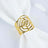 Gold rose design napkin ring on a white napkin.