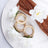 Wooden rings adorned with flowers and fabric on a white plate.