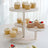 Three-tiered wooden serving stand with assorted cupcakes and desserts.