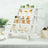 Colorful cupcakes displayed on a white wooden stand at a festive event.