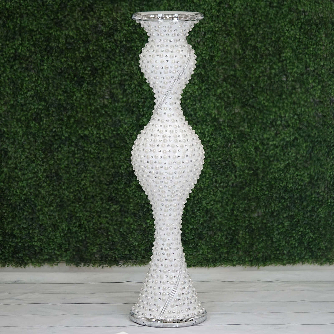 Elegant white decorative vase with crystal accents on a green backdrop.