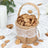 Decorative burlap basket filled with golden petals on a white background.