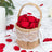 Red rose petals in a rustic burlap basket with lace trim.