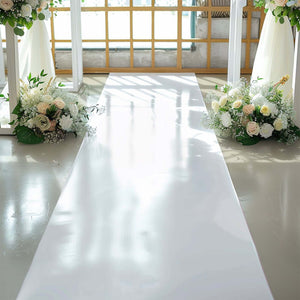 White aisle runner with floral arrangements on either side in a bright venue.