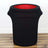 Black fabric storage bin with red interior on wooden floor.