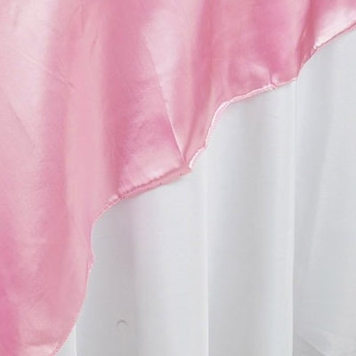 Pink satin fabric draped elegantly against a white backdrop.