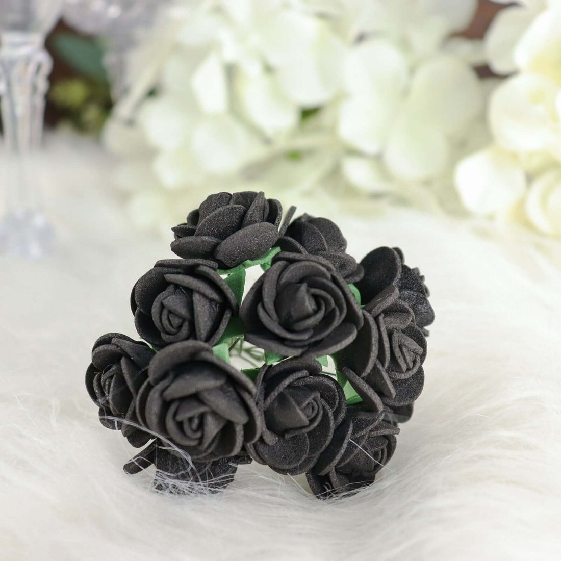 Black rose hair accessory on a soft textured background.